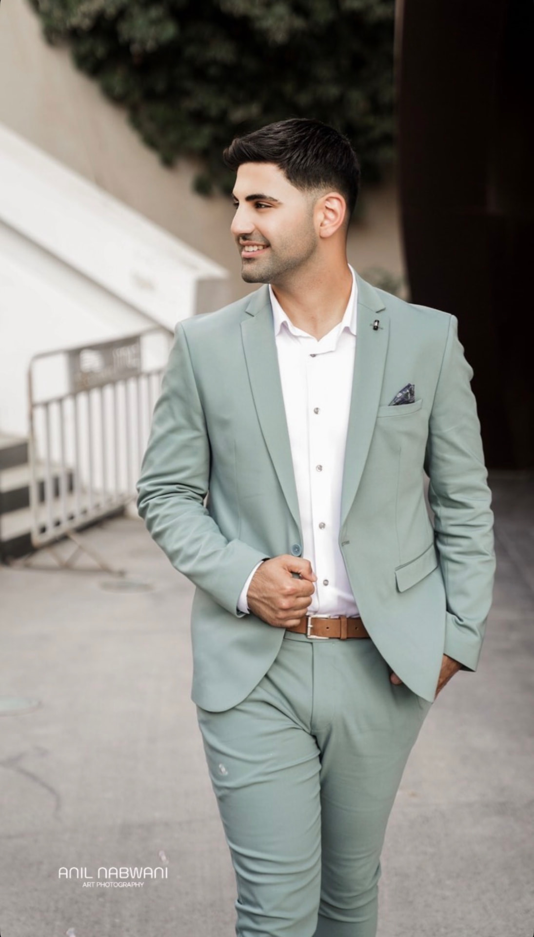 Portrait of the groom in a sage green suit