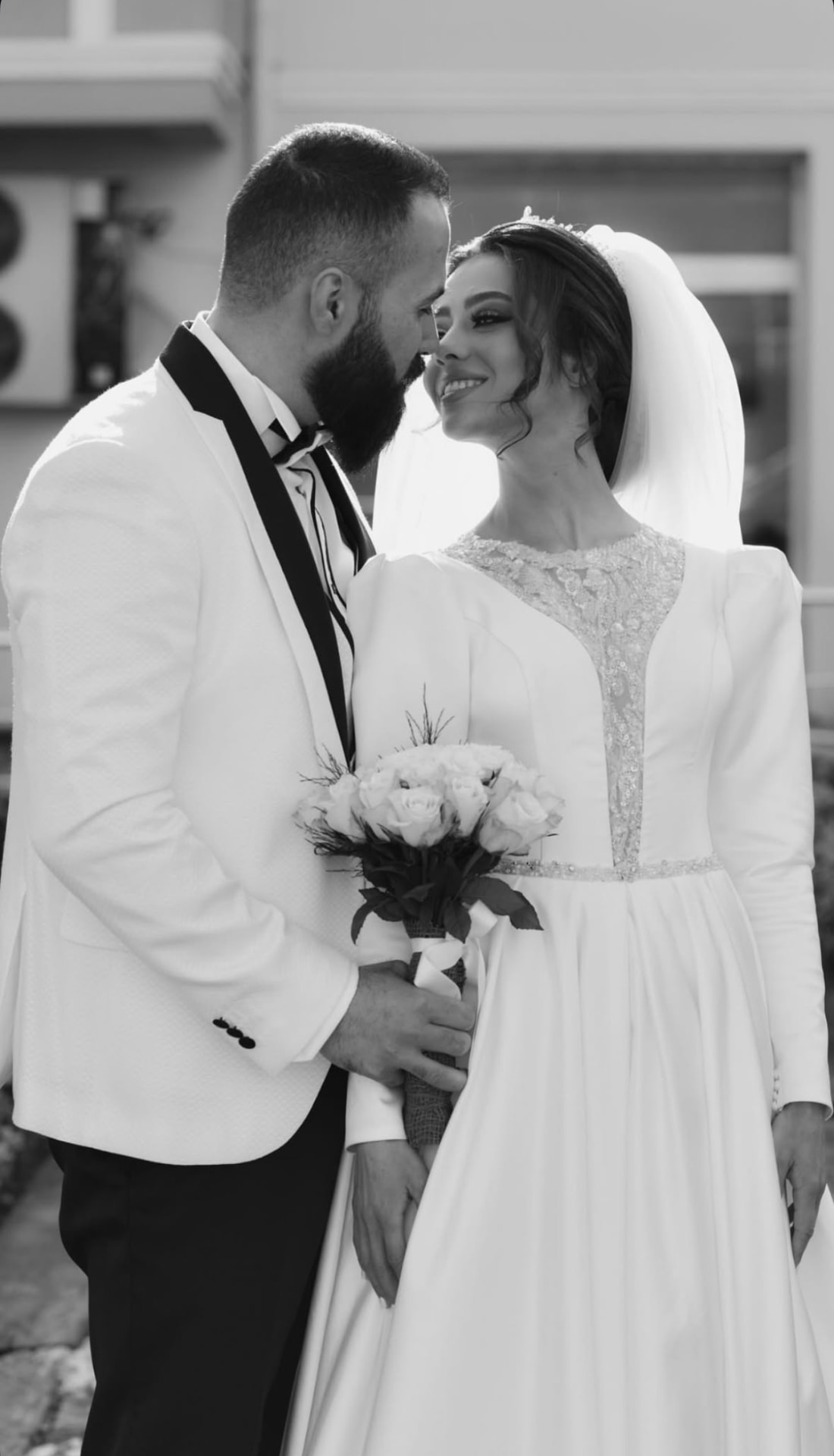 Black and white photograph of bride and groom forehead to forehead