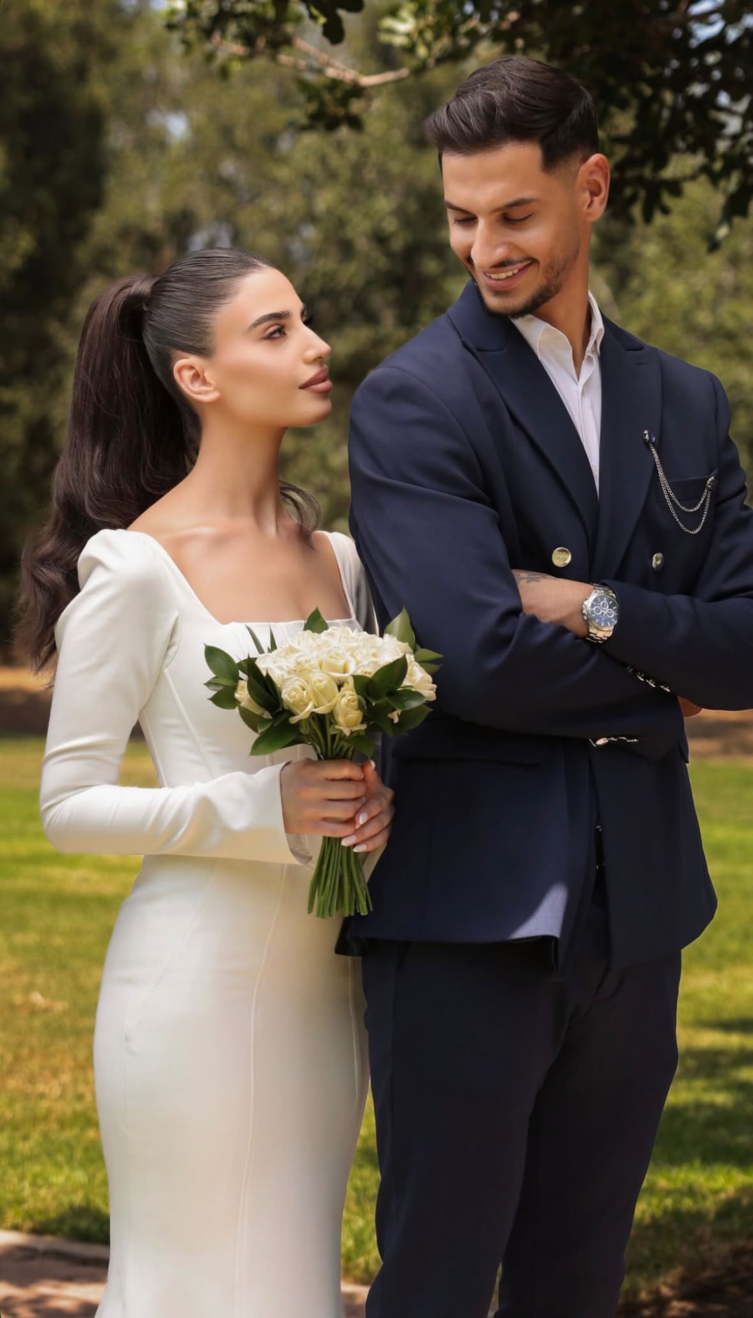 Bride with a white rose bouquet beside the groom in a navy suit