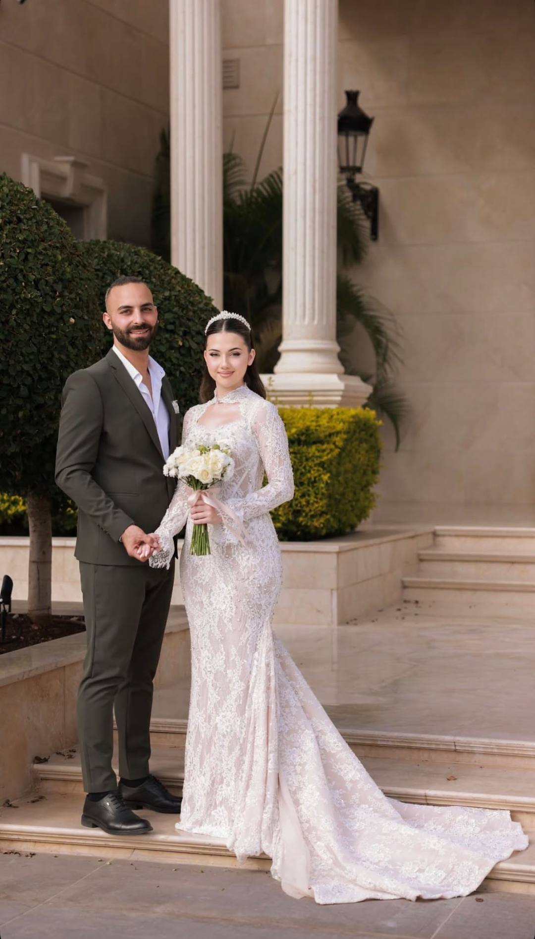 Newlywed couple posing together on grand marble steps