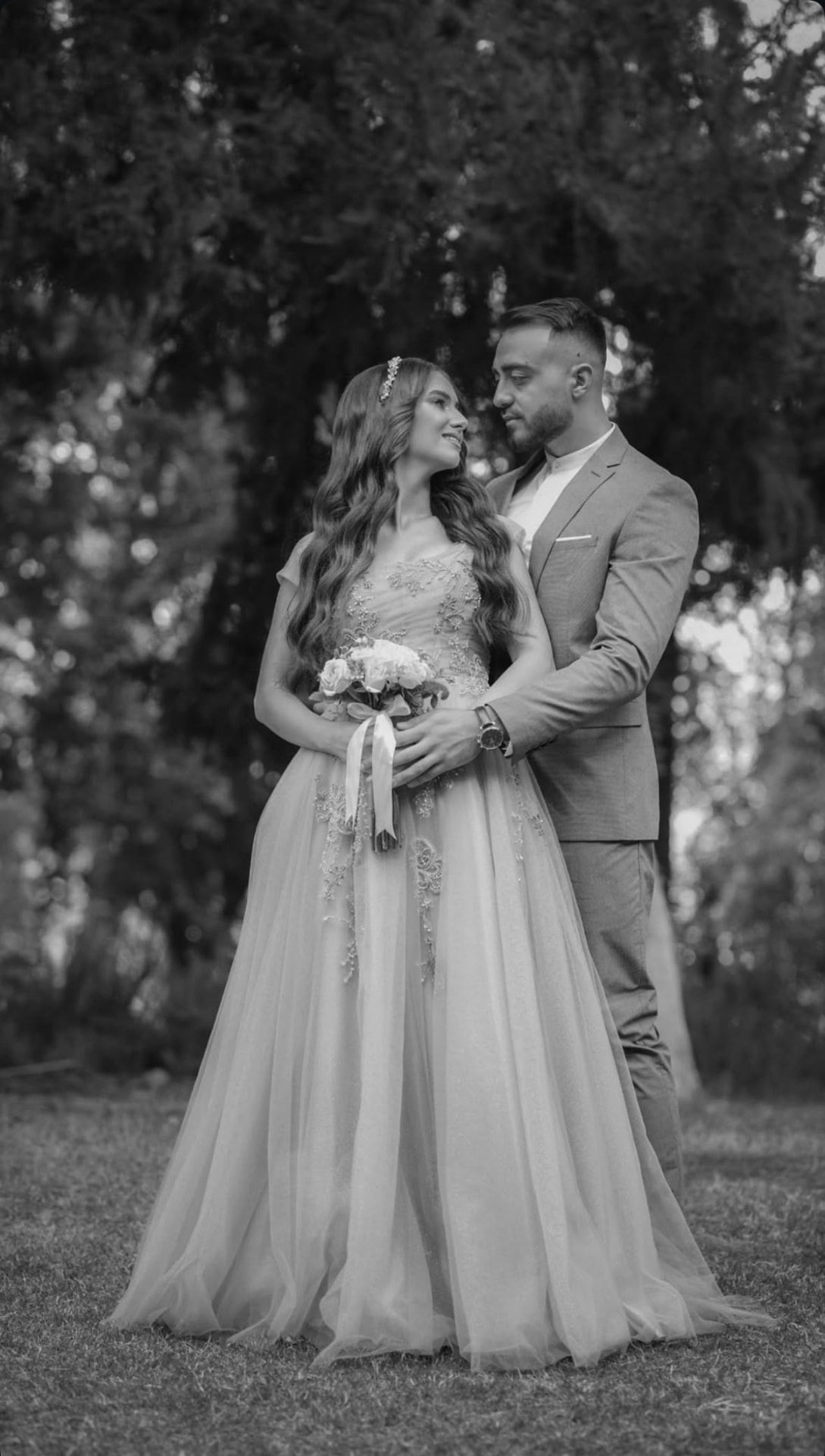 Black and white photograph of a couple embracing in a garden